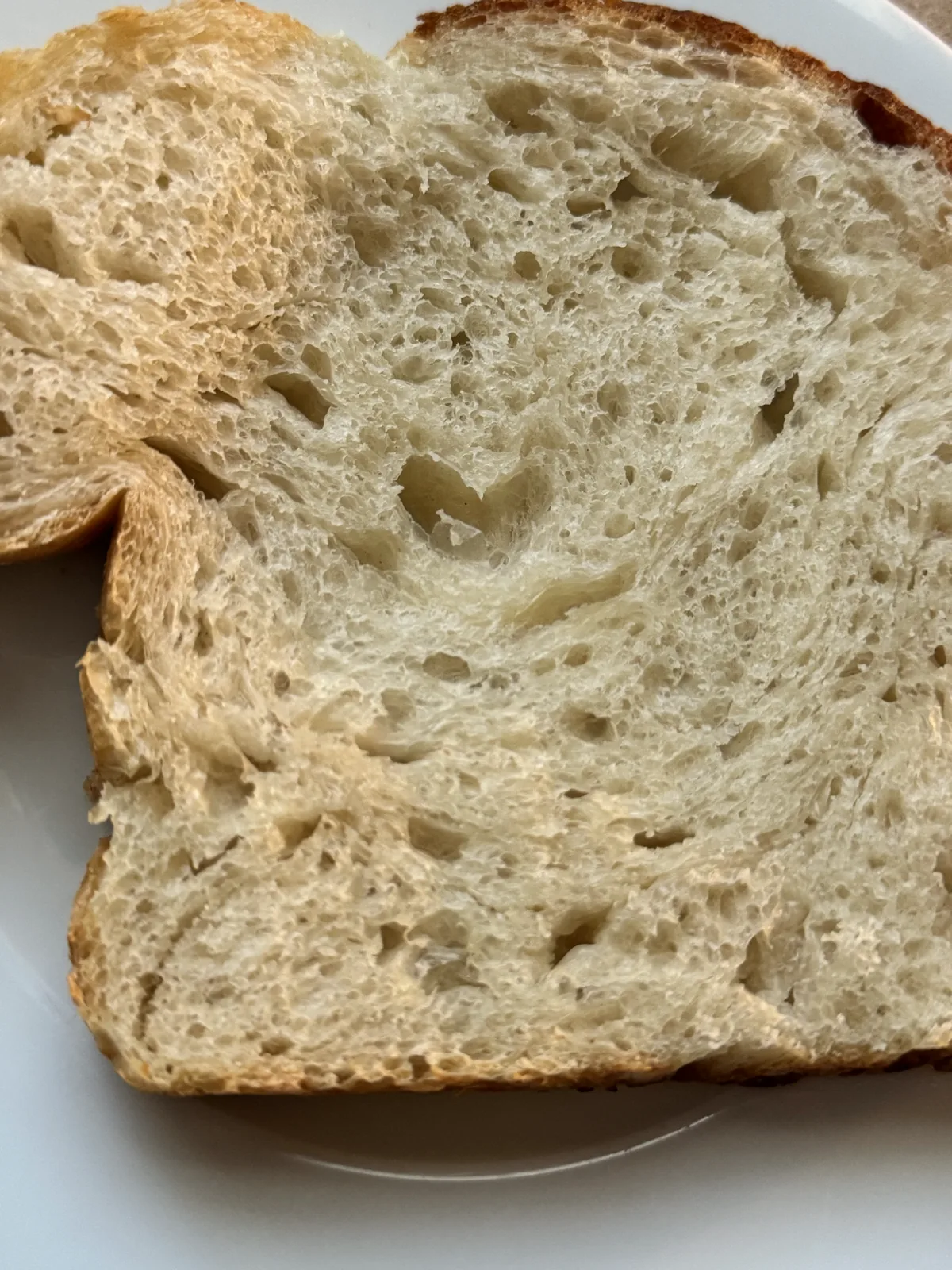 A slice of PinCH sourdough loaf on a white plate